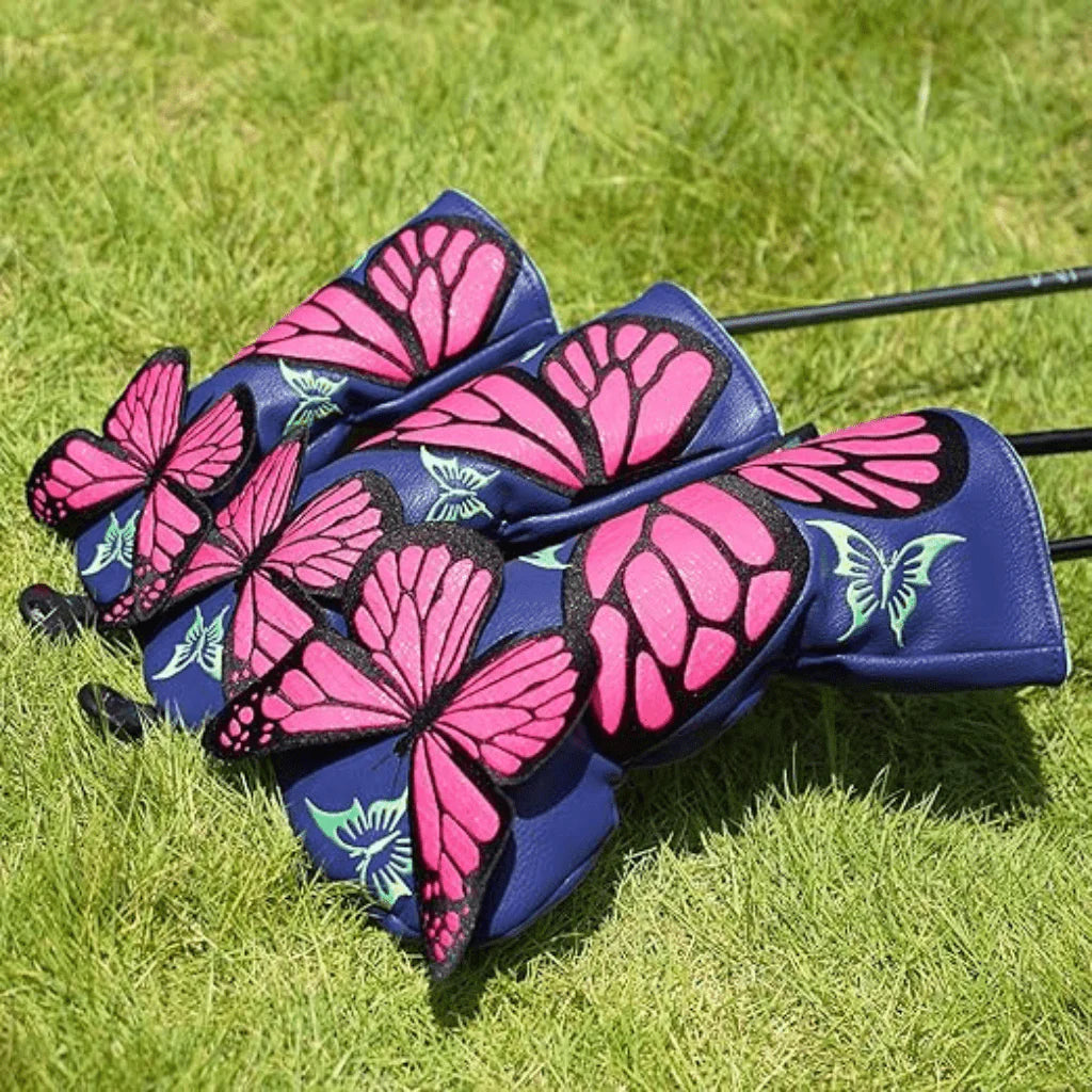 Golf club head covers with pink butterfly design on a grass background